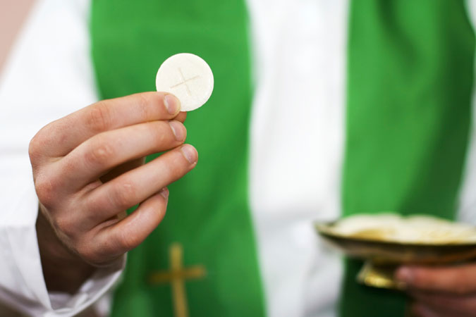 priest holding Communion host