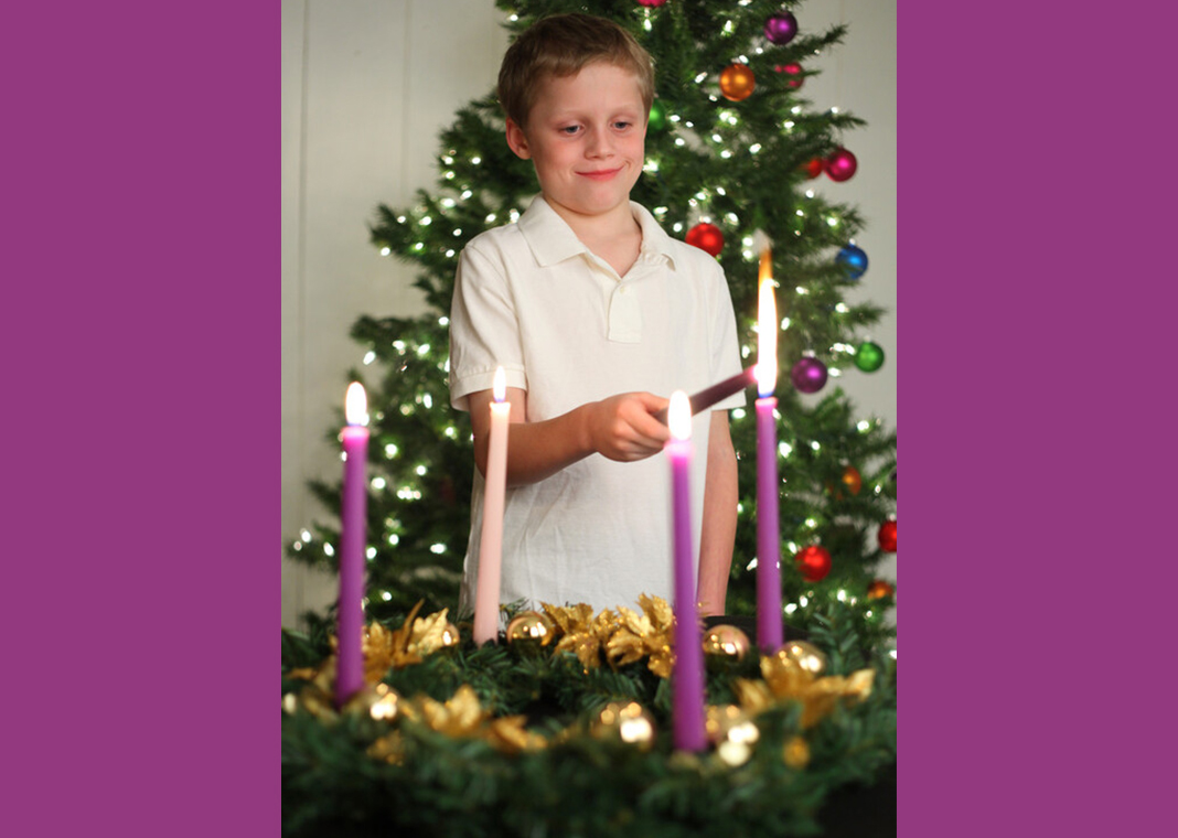 boy lighting candles of Advent wreath - huronphoto/iStock/Getty Images