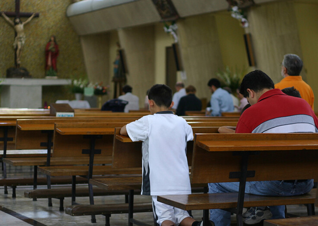 family praying in church - abalcazar/iStockGetty Images