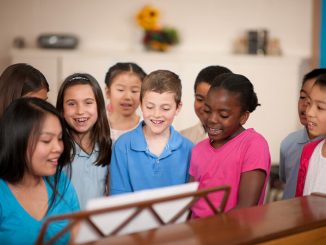 choir director leading children in song - Christopher Futcher/ FatCamera/E+/Getty Images