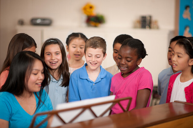 choir director leading children in song - Christopher Futcher/ FatCamera/E+/Getty Images