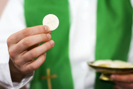 priest holding Communion host