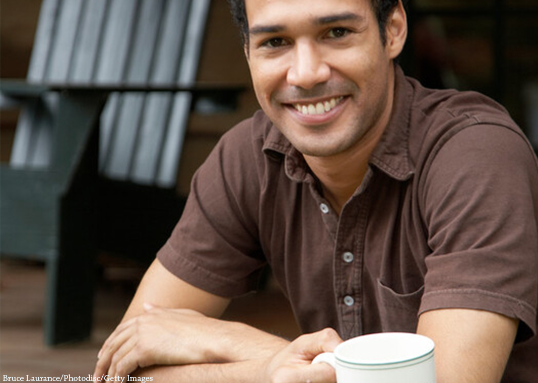 smiling young adult man with coffee cup - Bruce Laurance/Photodisc/Getty Images