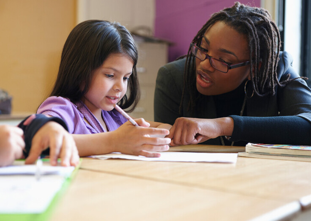 catechist with young girl at table - LWA/Dann Tardif/Blend Images/Digital Vision/Getty Images