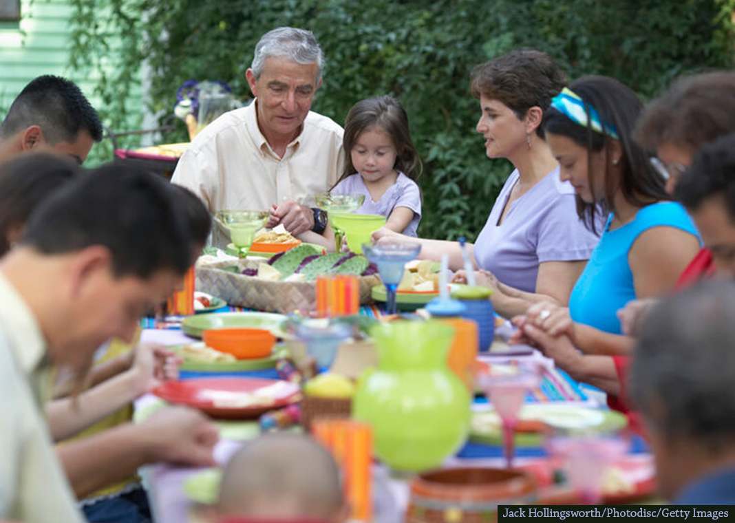 family praying before meal outdoors - Jack Hollingsworth/Photodisc/Getty Images
