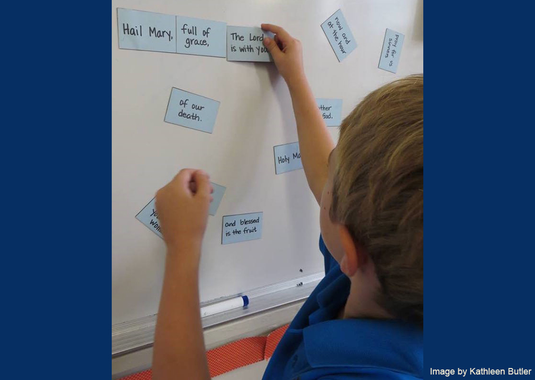 child at board with prayer cards - photo by Kathleen Butler