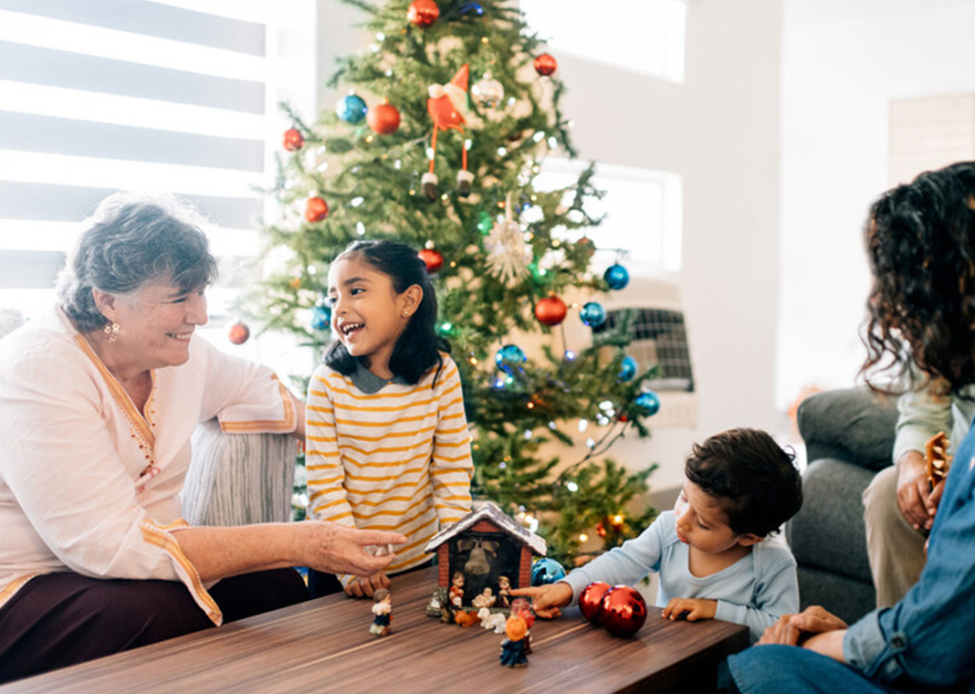 children celebrate Christmas with mother and grandmother - ferrantraite/E+/Getty Images