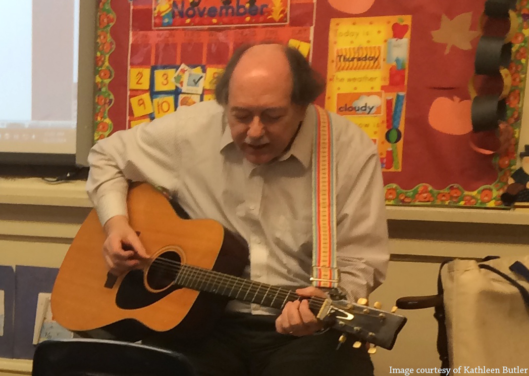 man playing guitar in classroom - image courtesy of Kathleen Butler