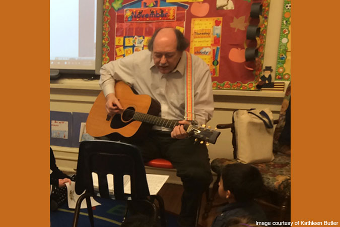man playing guitar in classroom - image courtesy of Kathleen Butler
