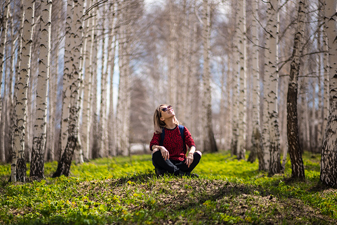 woman sitting under trees - photo by Baurzhan Kadylzhanov from Pexels