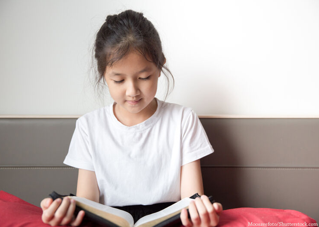 young girl reading Bible - Moosavefoto/Shutterstock.com