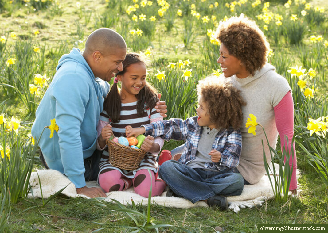 family celebrating Easter season in field of daffodils - oliveromg/Shutterstock.com