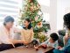 family telling stories around Christmas tree with Nativity scene in front of them - ferrantraite/E+/Getty Images